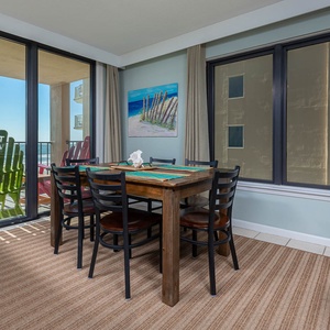 This inviting dining area features a wooden table, stylish black chairs, and a breathtaking view from the balcony