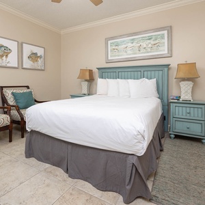 Relax in this inviting guest bedroom featuring a queen bed, coastal decor, and comfortable seating for your enjoyment