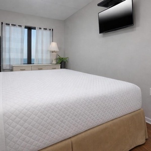 This inviting king master suite has a stunning view through large windows, perfect for relaxation