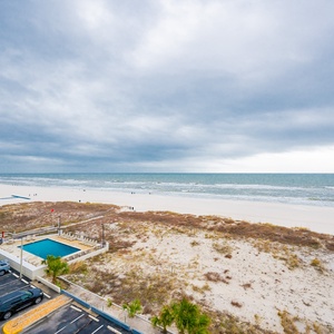 This view showcases a serene beachfront with soft sand and gentle waves, perfect for relaxation and enjoyment