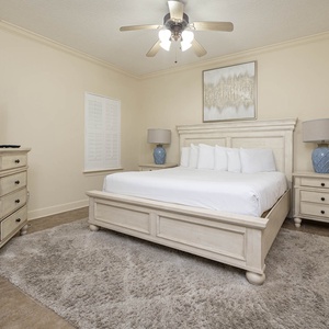 Serene master bedroom featuring a plush king bed, a large TV, and soft lighting for a restful retreat