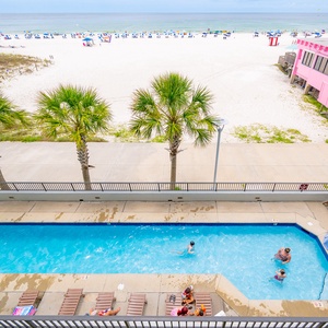 Enjoy refreshing dips in the inviting pool, with palm trees swaying and the beach nearby