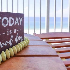 Enjoy a refreshing view from the balcony with a wooden sign that reads, 