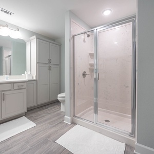 Freshen up at the long vanity under bright lights, then step into the glass shower to rinse and relax