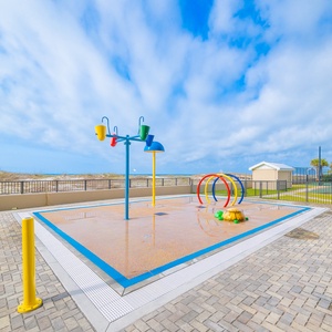 Vibrant playground and splash area, featuring colorful equipment and a soft play surface for family fun and laughter