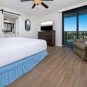 Spacious master suite featuring a king bed, a cozy seating area, and access to a lovely balcony view