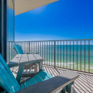 Relax on the turquoise chairs of this inviting balcony, offering breathtaking views of the sparkling waters below