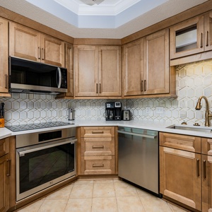 Craft your favorite meals surrounded by modern stainless appliances and wooden cabinetry on your coastal retreat