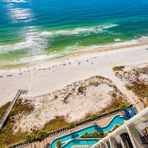 This balcony view showcases a vibrant blue sea and sandy shore overlooking the lazy river, perfect for relaxing by the water