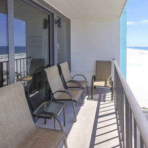Enjoy relaxing moments on the balcony with comfortable seating and stunning beachfront views