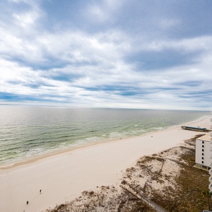 This stunning view showcases a serene beachfront with soft sand and gentle waves, perfect for relaxation