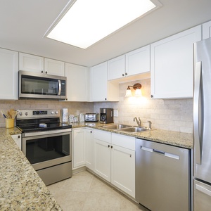 Bright modern kitchen features granite countertops, sleek stainless appliances, and ample cabinetry