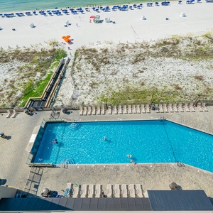 Take a refreshing dip in the inviting pool while enjoying views of the beach and lounge chairs nearby