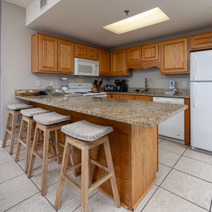 Warm wood cabinetry complements the spacious breakfast bar in this kitchen, creating an inviting atmosphere