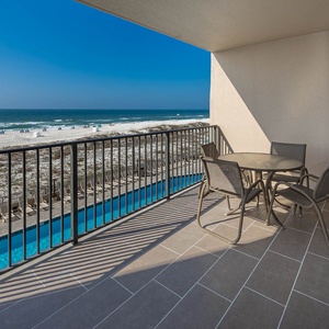 Relax at the outdoor table while enjoying views of the beach and the inviting pool area below