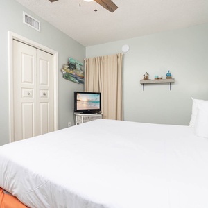 Unwind in this serene bedroom featuring a plush king bed, a flat-screen TV, and coastal decor for a relaxing getaway