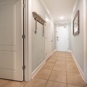 Step into a welcoming hallway adorned with beach decor, leading to cozy bedrooms and inviting spaces