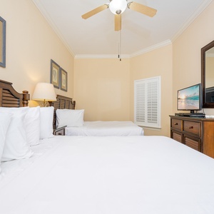 Guest bedroom featuring two comfortable queen beds, a flat-screen TV, and warm, inviting decor