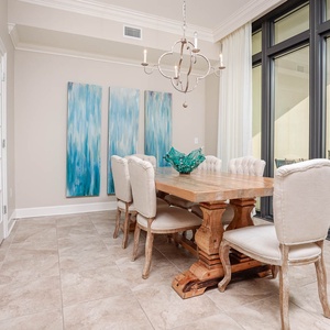 This elegant dining area features a rustic table with six upholstered chairs, with stunning views through large windows