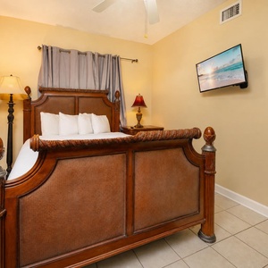 Retreat to this inviting guest bedroom featuring a queen bed, soft linens, and a TV for your entertainment