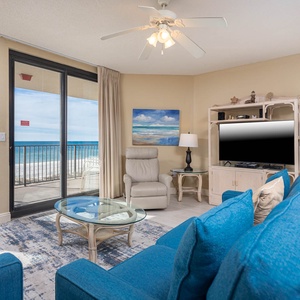 Relax in the inviting living area featuring a sofa with queen sleeper, flat-screen TV, and stunning beach views