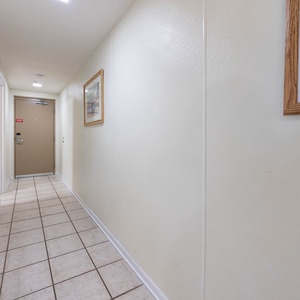 Step into a welcoming hallway adorned with artwork, leading you to your beachfront vacation retreat