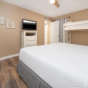 This cozy bedroom features a comfortable full bed, a TV for entertainment, and a charming twin bunk bed for extra guests