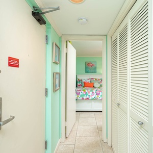 Brightly colored entryway leading to a cozy guest bedroom with vibrant floral bedding and cheerful decor