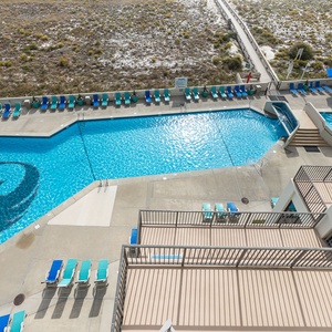 Vibrant pool area features a large geometric pool with lounge chairs and umbrellas, perfect for relaxation under the sun