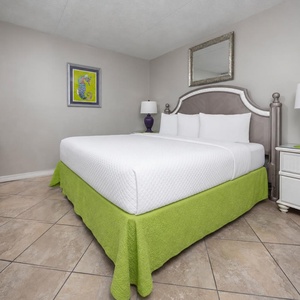 This guest room features a king bed with vibrant green accents, perfect for a restful getaway