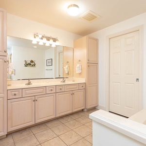 Experience this spacious master bathroom featuring dual sinks, ample storage, and a relaxing jetted tub for your comfort