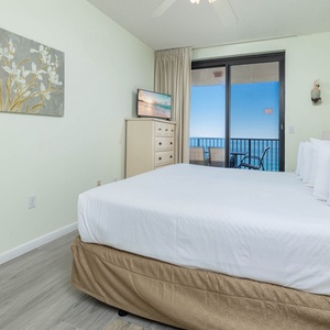 Relax in the comfortable master bedroom with a king bed, a TV, and easy access to a balcony offering beautiful views