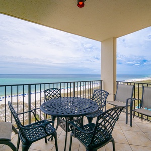Stunning beachfront view showcases the tranquil beach, inviting pool area, and nearby resort buildings from the balcony