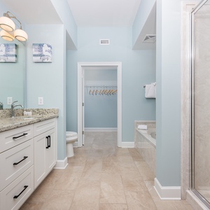 Experience relaxation in the master bathroom featuring a dual vanity, soothing tub, and walk-in shower