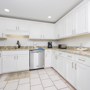 Prepare meals in the sleek kitchen featuring granite countertops, stainless appliances, and ample storage space