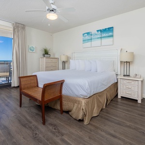 Unwind in this spacious master bedroom featuring a king bed, stylish decor, and direct access to a balcony with beach views