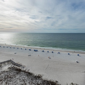 Stunning view of soft serene beach with blue umbrellas under a serene sky, perfect for a relaxing getaway