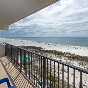 Enjoy a stunning beachfront view from the balcony with bright blue chairs, perfect for relaxation and soaking in the scenery