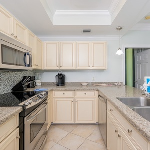 Prepare meals in this kitchen with elegant cabinetry, stainless appliances, and spacious countertops