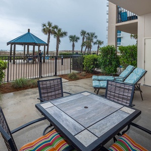Relax on the patio with access to the pool and beach, surrounded by lush greenery and views of the gazebo area