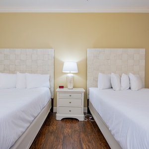 Rest comfortably in this guest room with two queen beds, ready for family fun after beach adventures