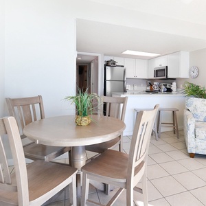 Gather around the round dining table for meals or games in this cozy hotel suite with a complete kitchen