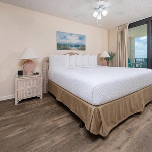 Unwind in the master bedroom featuring a king bed, coastal decor, and beachfront balcony access