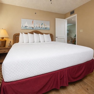This guest bedroom features a king bed, nautical artwork, and warm lighting, perfect for a relaxing getaway