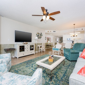 Unwind in the inviting living area, featuring a sofa with queen sleeper and large TV, perfect for relaxing after a beach day