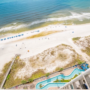 Aerial view of pristine beach from the balcony, colorful umbrellas, and the lazy river, perfect for a relaxing getaway