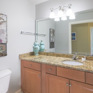 Additional half bath with a spacious vanity and coastal accents for convenience during your stay