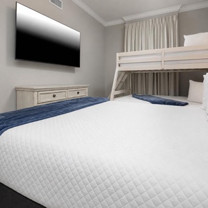 Unwind with a movie in this cozy bunk room with a fluffy queen and two twin bunk beds