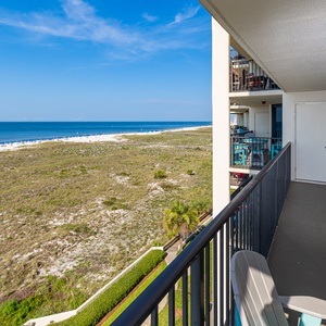 Chairs await you on your balcony where you can watch beach umbrellas dotting the coast below