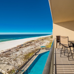 Sip your morning coffee at the outdoor table while enjoying stunning views of the beach and the inviting pool below